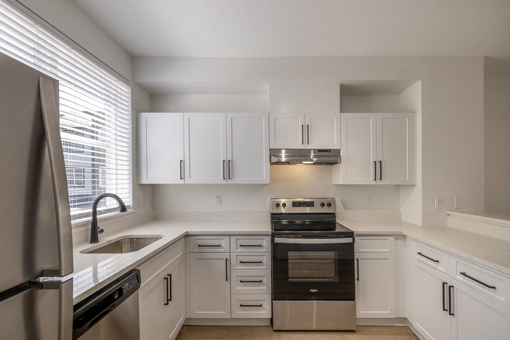 a kitchen with white cabinets and a black stove top oven