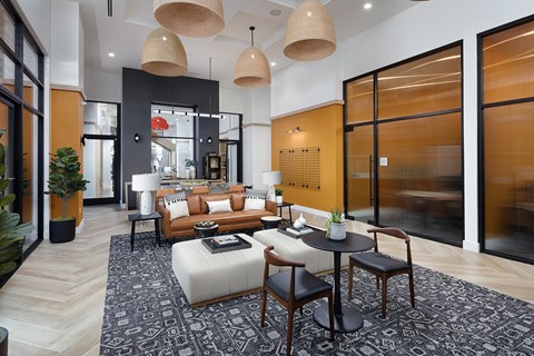 A modern living room with a black and white rug and wooden furniture.