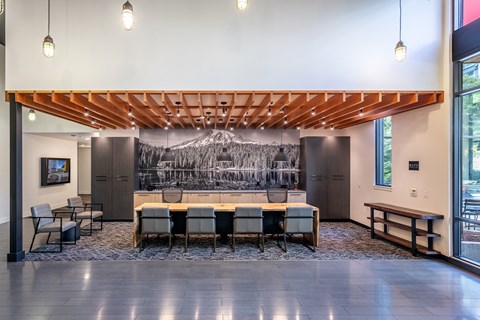 A conference room with a long table and chairs, a wooden ceiling, and a large black and white mural on the wall.