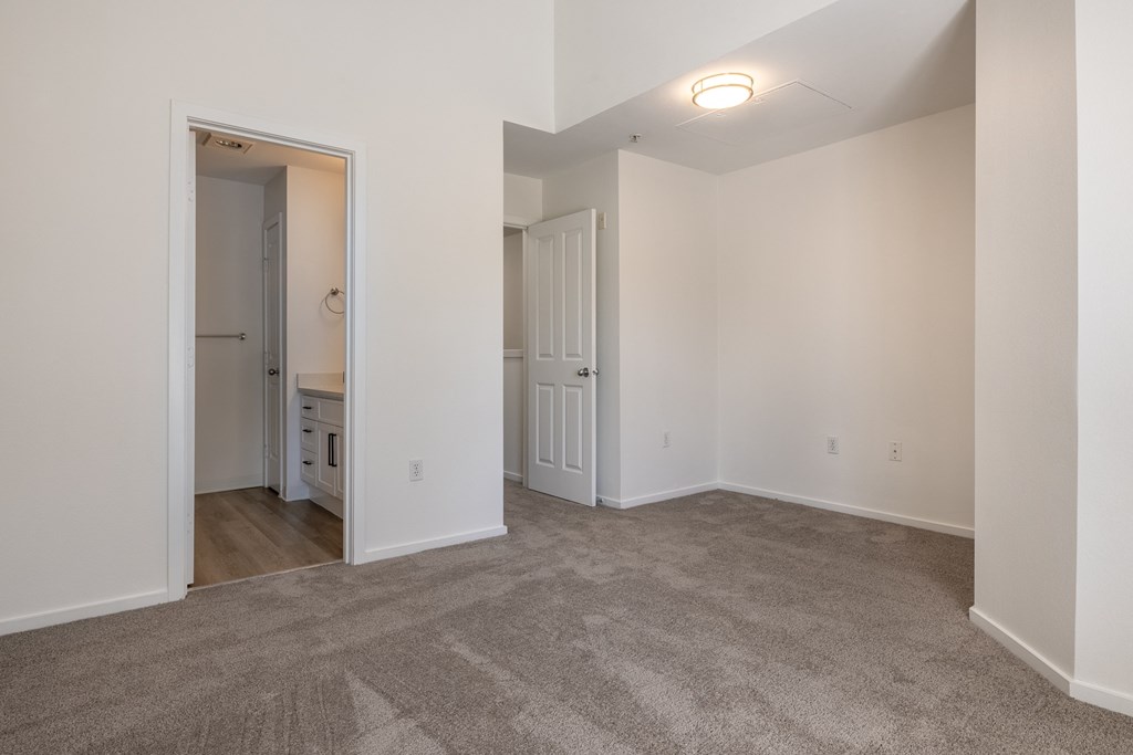 a bedroom with white walls and carpet
