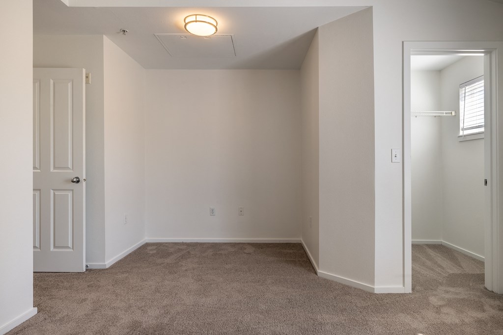 a bedroom with a carpeted floor and a white door