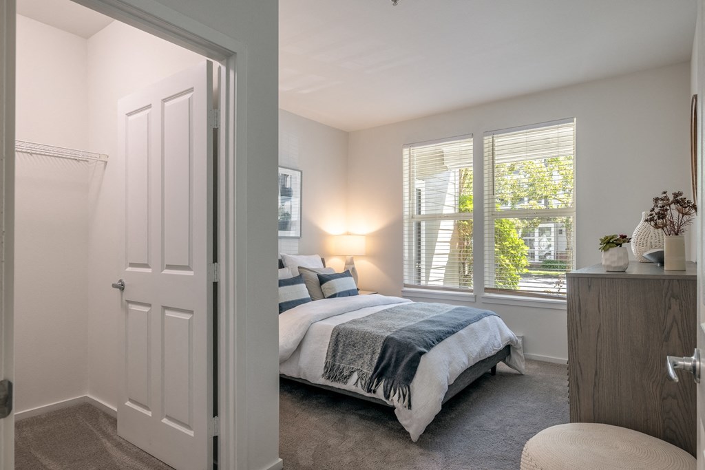 a bedroom with a bed and two windows