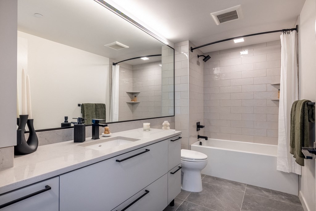a bathroom with a white toilet and a white tub with a shower curtain