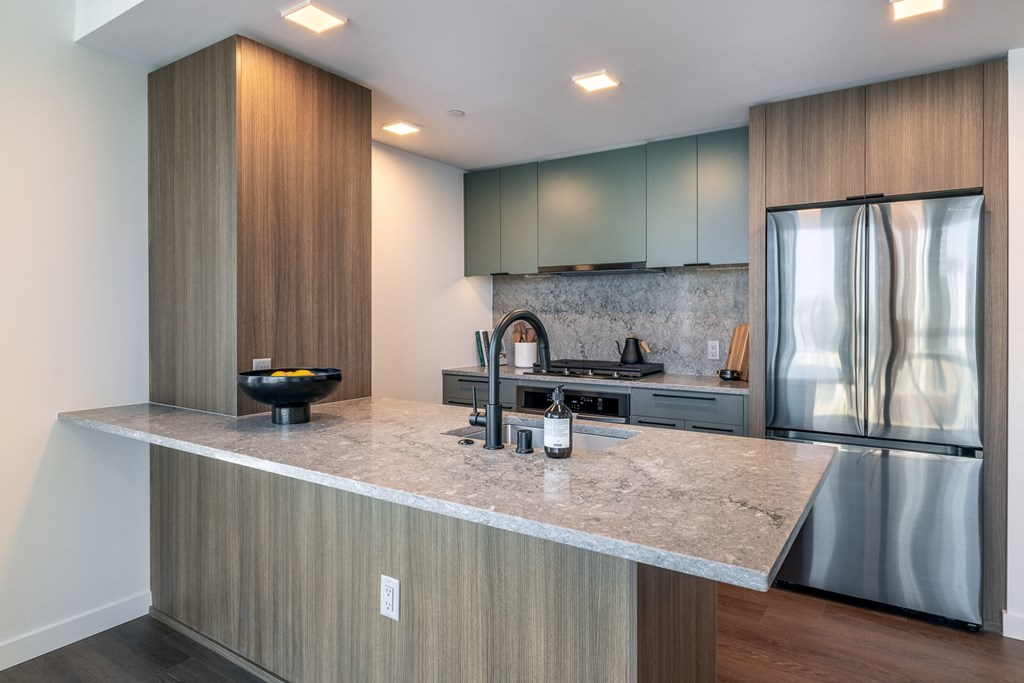 a kitchen with a large island and stainless steel appliances