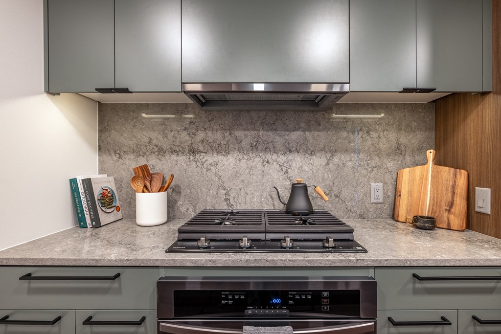 a kitchen with a stove top oven next to a wooden cutting board