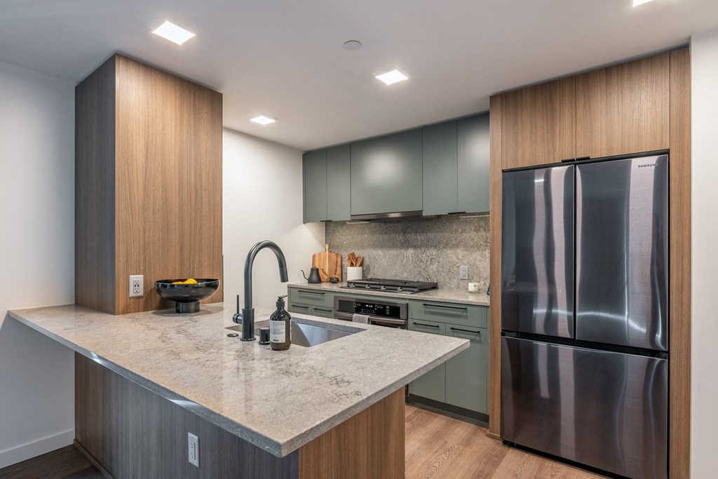 a kitchen with a large island and stainless steel appliances