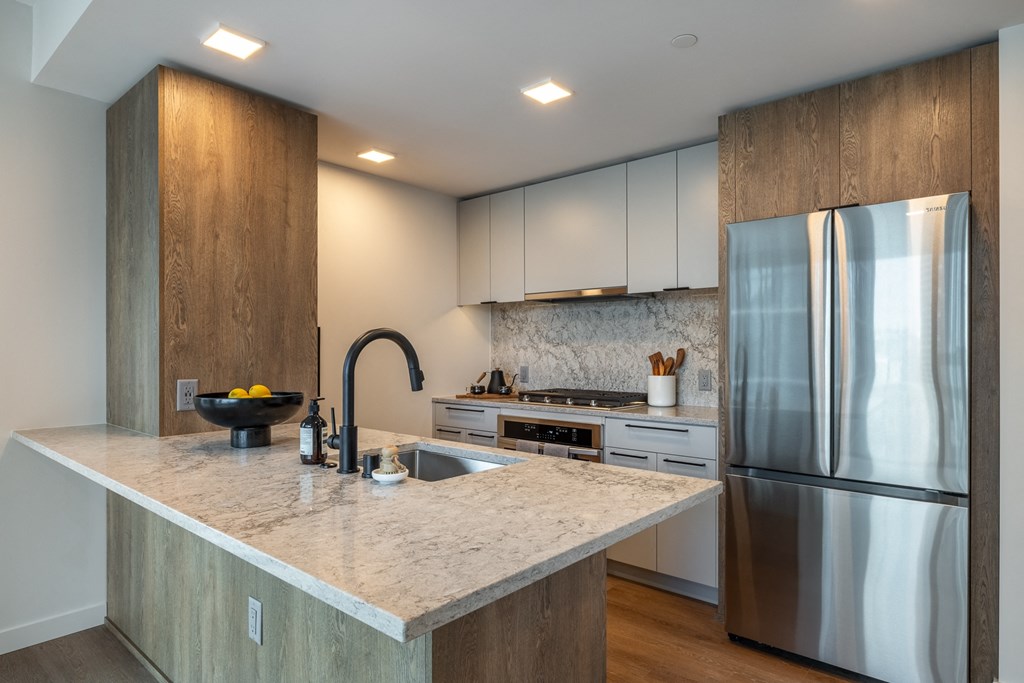 a kitchen with a large island and stainless steel appliances