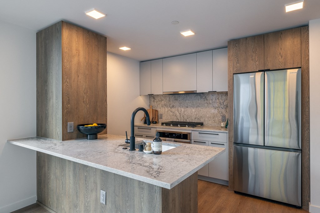 a kitchen with a large island and stainless steel appliances