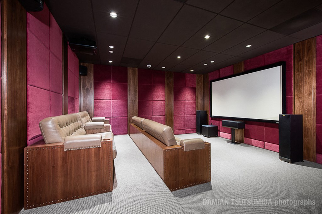 a cinema room with a large screen and leather couches