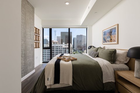 A bedroom with a large bed and a view of the city.