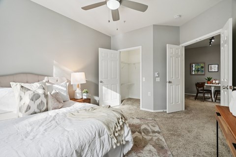 A bedroom with a large bed and a ceiling fan.