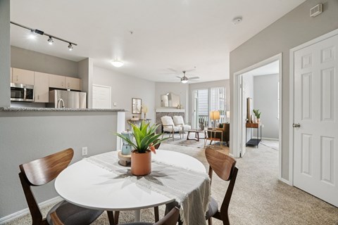 A dining room with a white table and chairs.