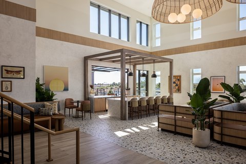 A large, open-plan living space with a staircase on the left and a long row of chairs on the right.