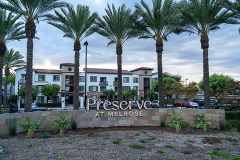 Palm trees in front of a sign that says "Preserve at Melrose".