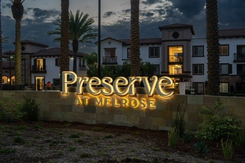 A sign that says "Preserve at Melrose" in front of some houses.