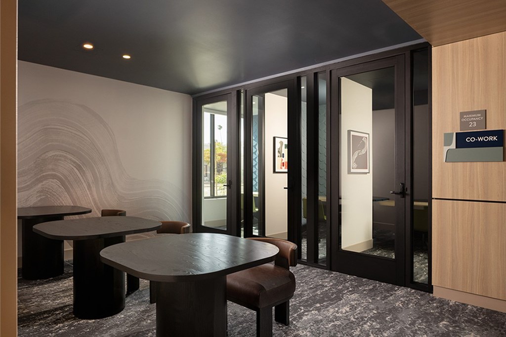 A room with a table and chairs and a sign that says "CO-WORK".