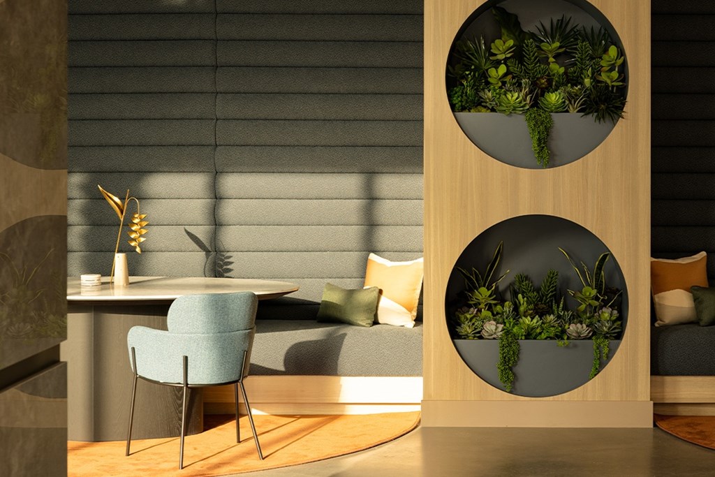 A modern dining area with a blue chair and a table with a vase of flowers.