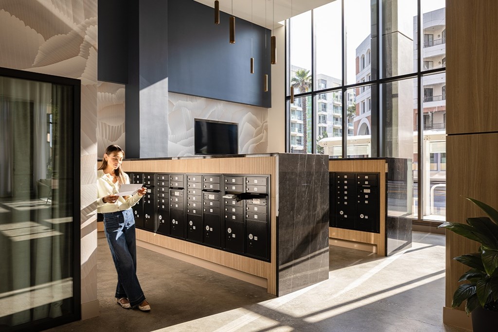 A woman is standing in front of a control panel in a modern building.