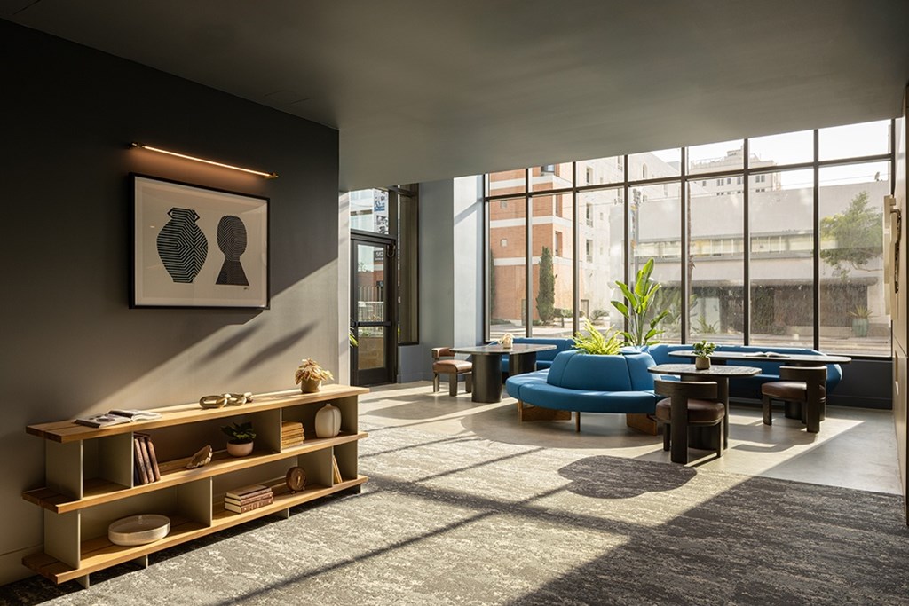 A modern living room with a blue sofa and a wooden shelf.