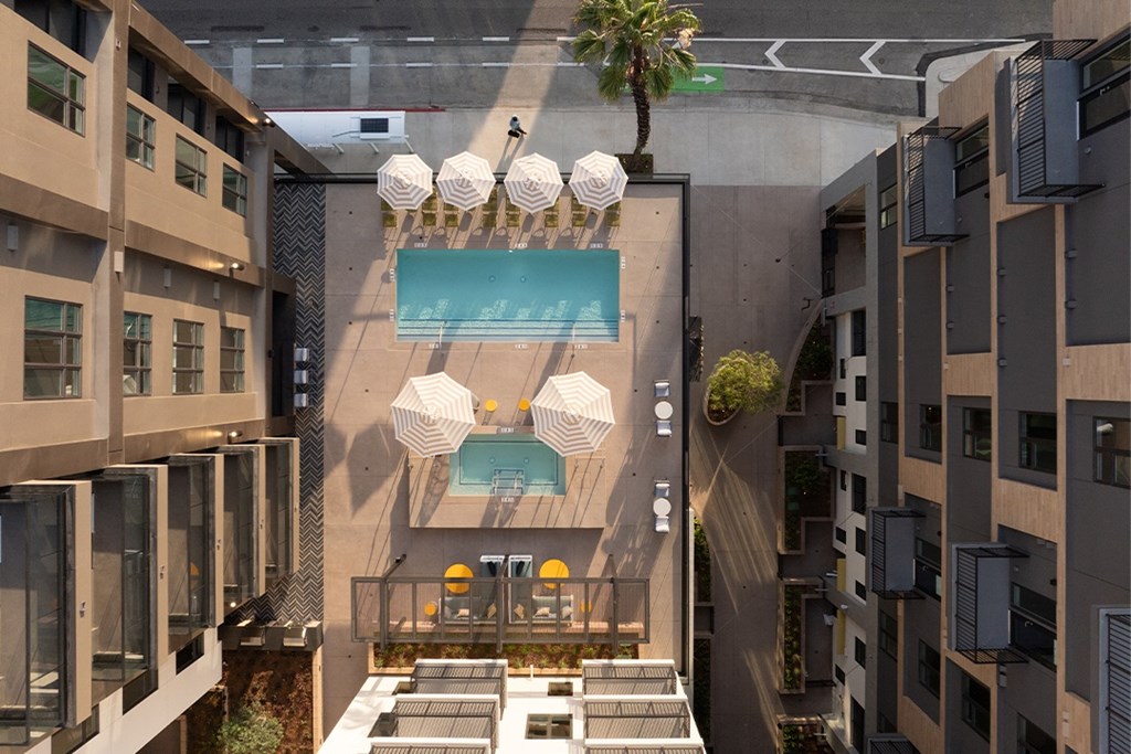 A modern outdoor seating area with a pool and umbrellas.