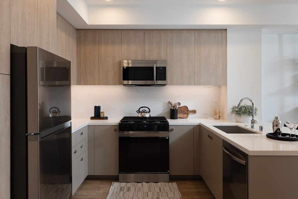 A modern kitchen with stainless steel appliances and wooden cabinets.