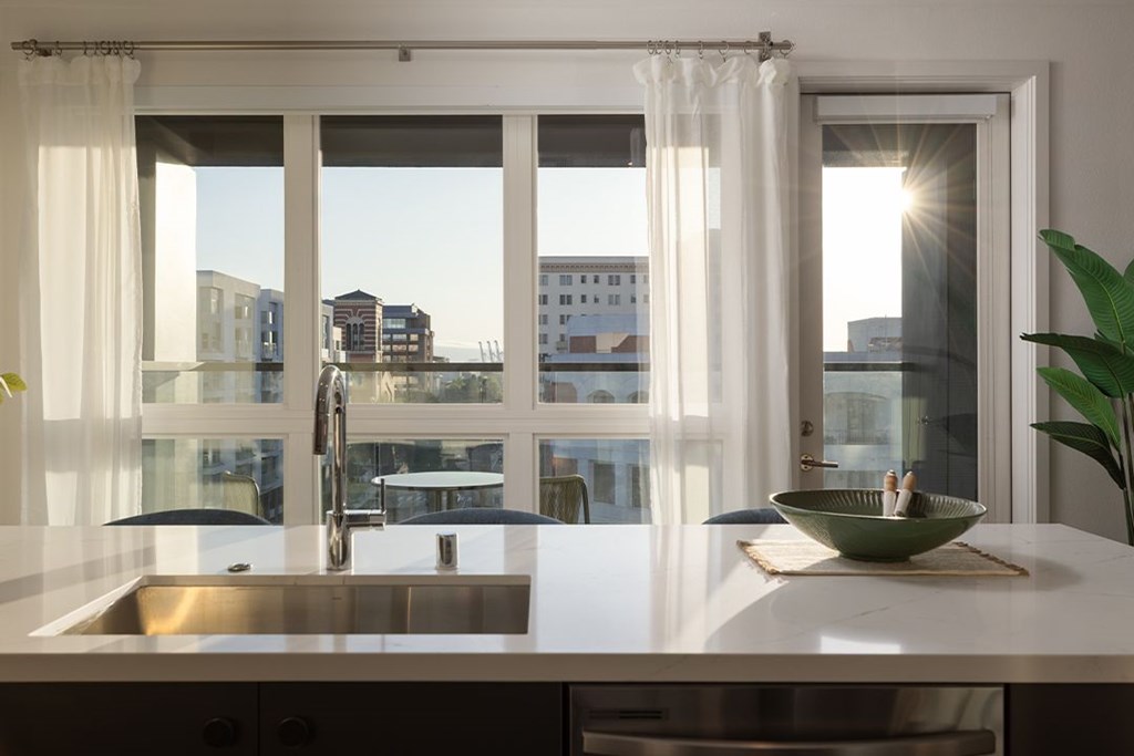 A modern kitchen with a large window overlooking the city.