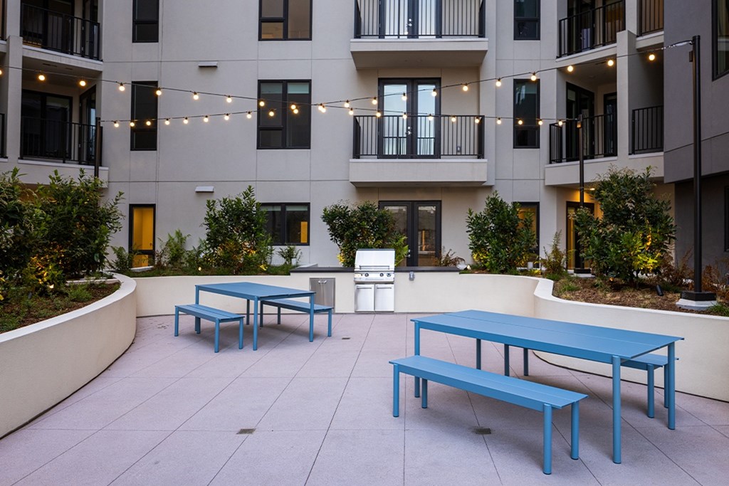 A patio with blue furniture and a white fridge.