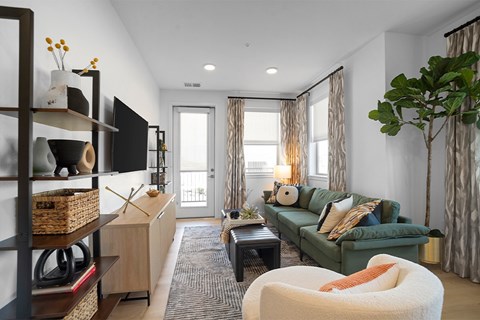 A living room with a green couch and a white chair.