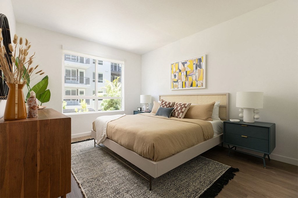 a bedroom with a large bed and two windows