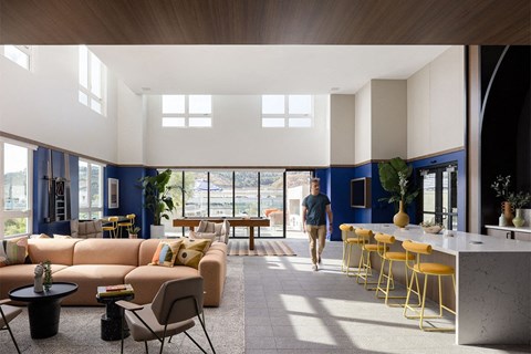 a man walks through a large living room with blue walls and white ceilings
