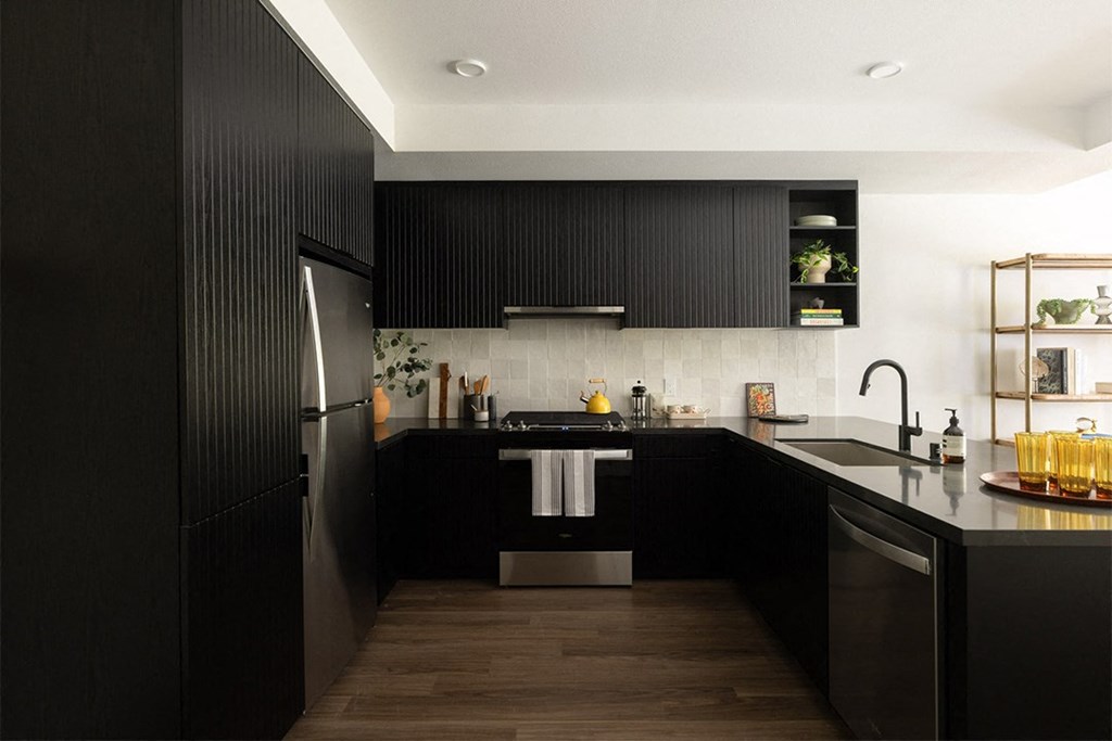 a kitchen with black cabinets and white walls