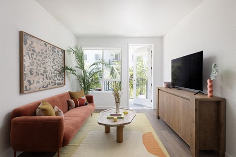 a living room with a red couch and a wooden coffee table
