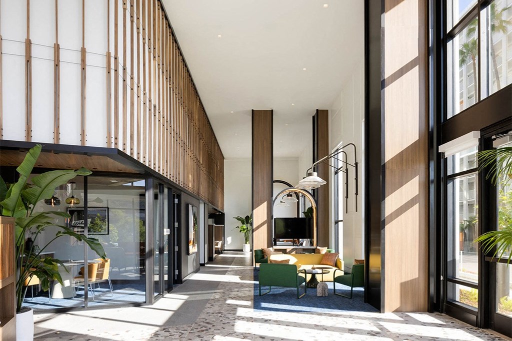 a view of the lobby of the hotel with green chairs and yellow couches