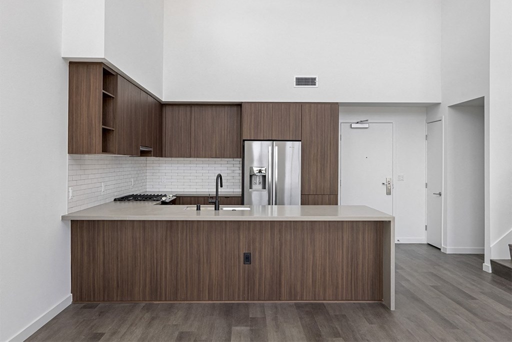 a kitchen with white walls and a wooden floor