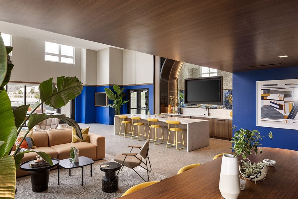 a living room with blue walls and a kitchen with a table and chairs