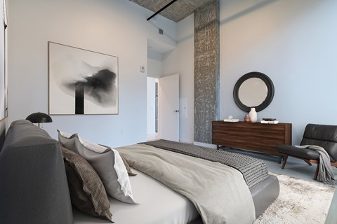 A modern bedroom with a large bed and a painting on the wall.