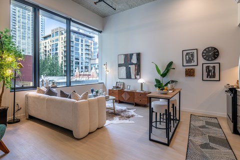 A living room with a white couch and a large window.