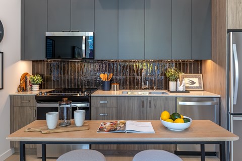 A modern kitchen with a wooden table and chairs.