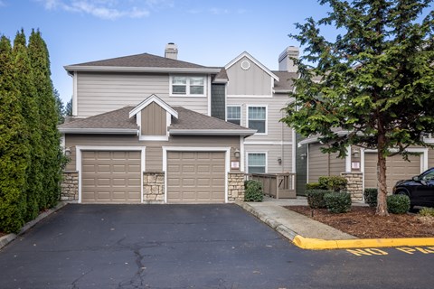 A house with a grey roof and a garage door.