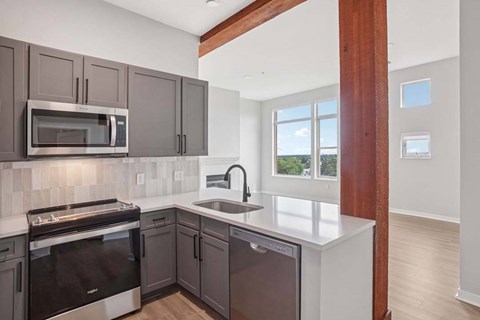 A kitchen with a white counter top and dark brown cabinets.