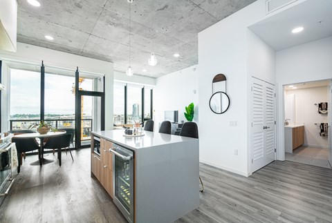 A modern kitchen with a large island and a dining table with chairs.