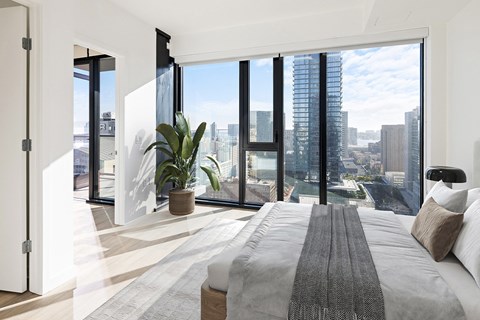 A bedroom with a large bed and a view of the city.