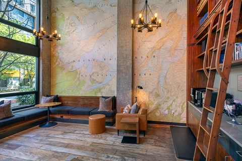 A room with a large map on the wall and a wooden staircase.