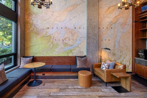 A large map of the United States is displayed on the wall of a room with a couch and a table.