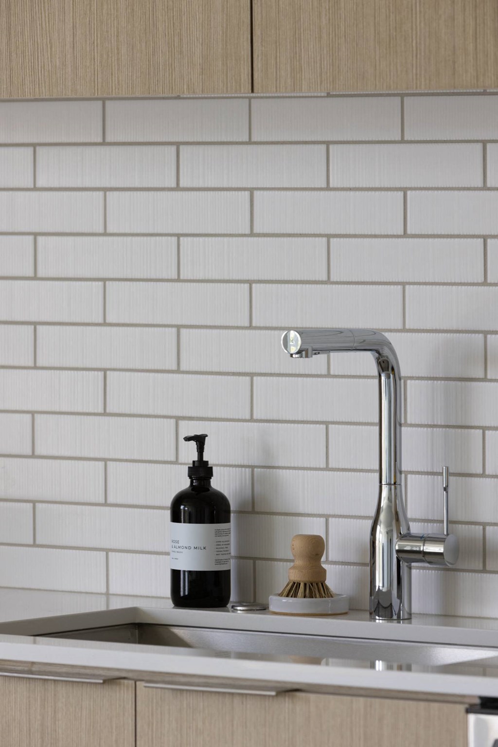 a sink with a soap dispenser and a bottle of soap on it
