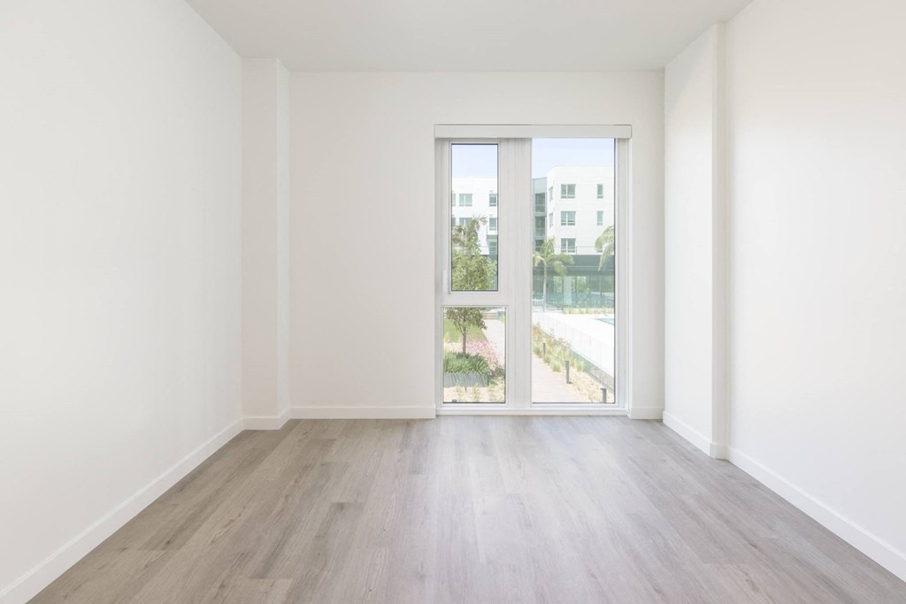 a living room with white walls and a sliding glass door