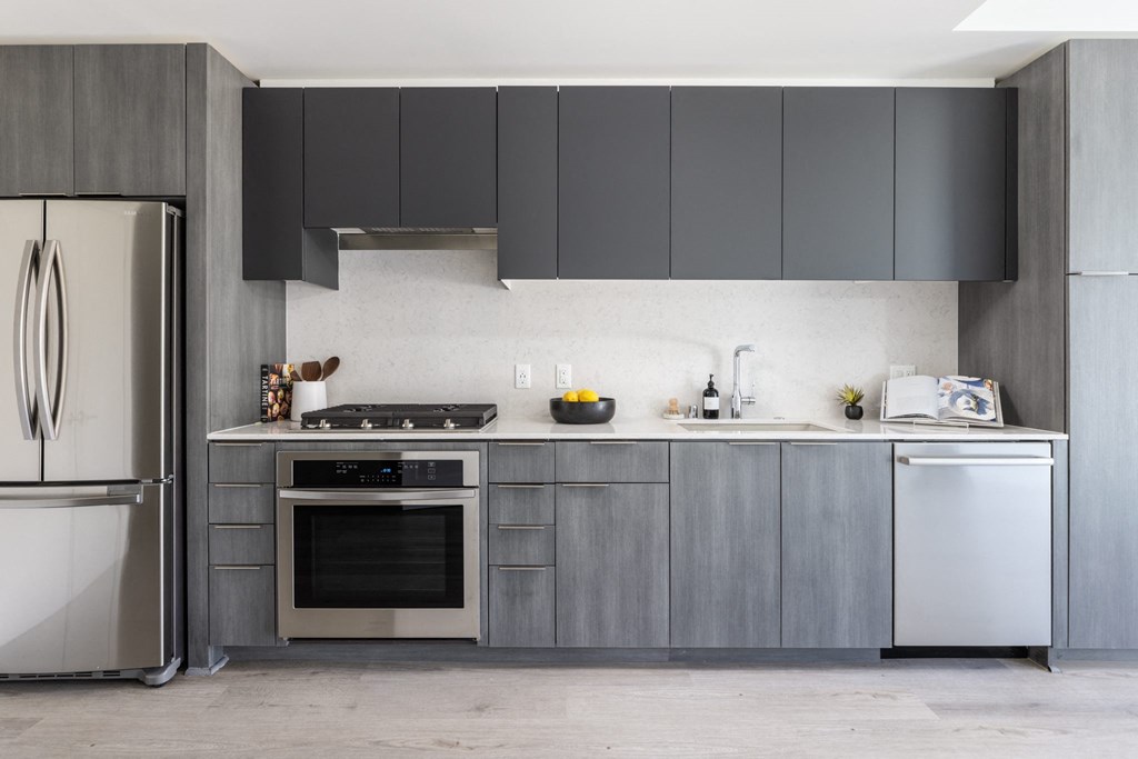 a kitchen with stainless steel appliances and gray cabinets