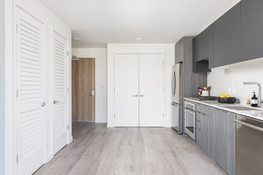 a kitchen with white cabinets and a sink and a refrigerator