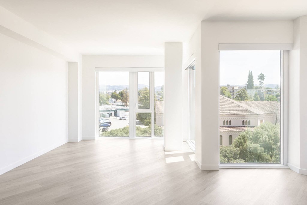 an empty living room with white walls and a window