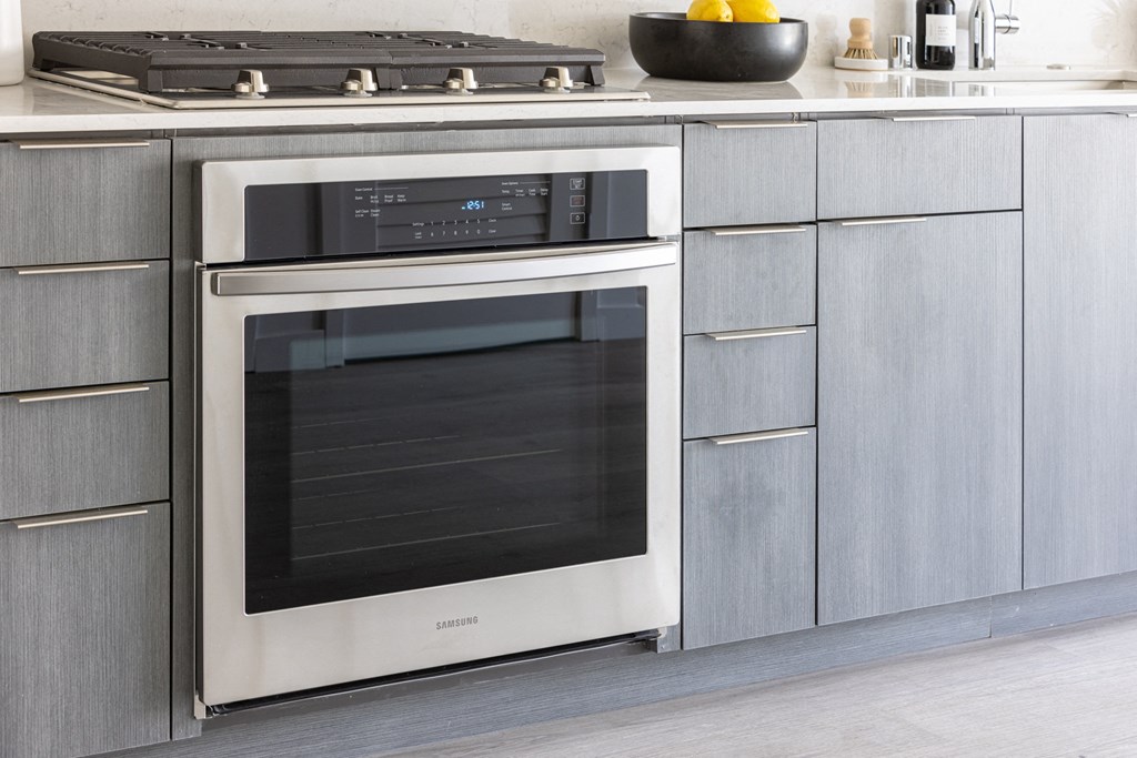 a stainless steel oven in a kitchen with silver cabinets